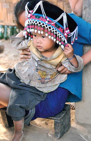 Photo of Hmong Child with Mother's Festive Headdress