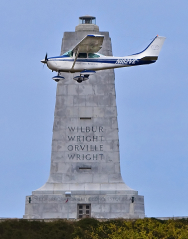 Photo of Bob Gannon flying past the Wright Brothers Monument