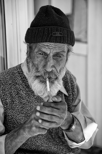 Man in Cap Lighting Cigarette in B&W - Bergama, Turkey - © 2014 Ralph Velasco